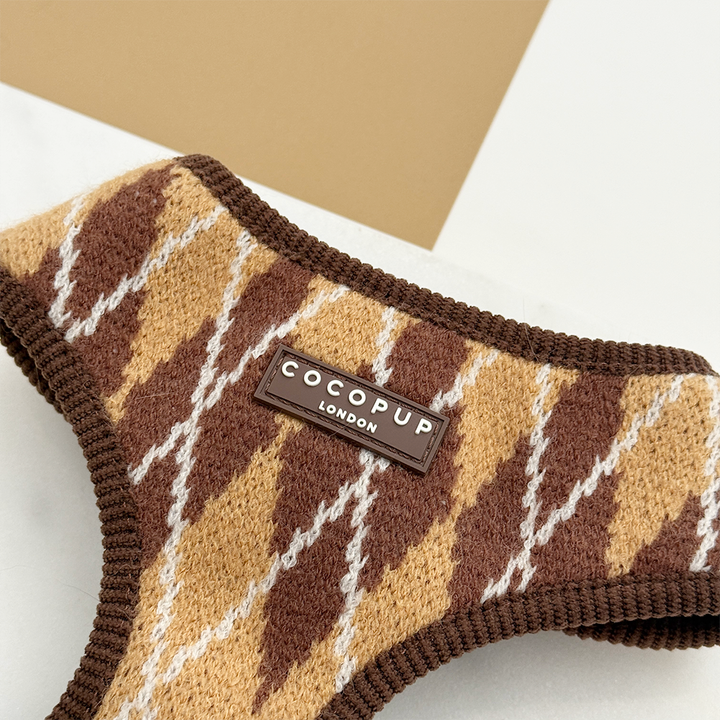Close-up of knit dog harness with a brown, tan, and white argyle pattern.