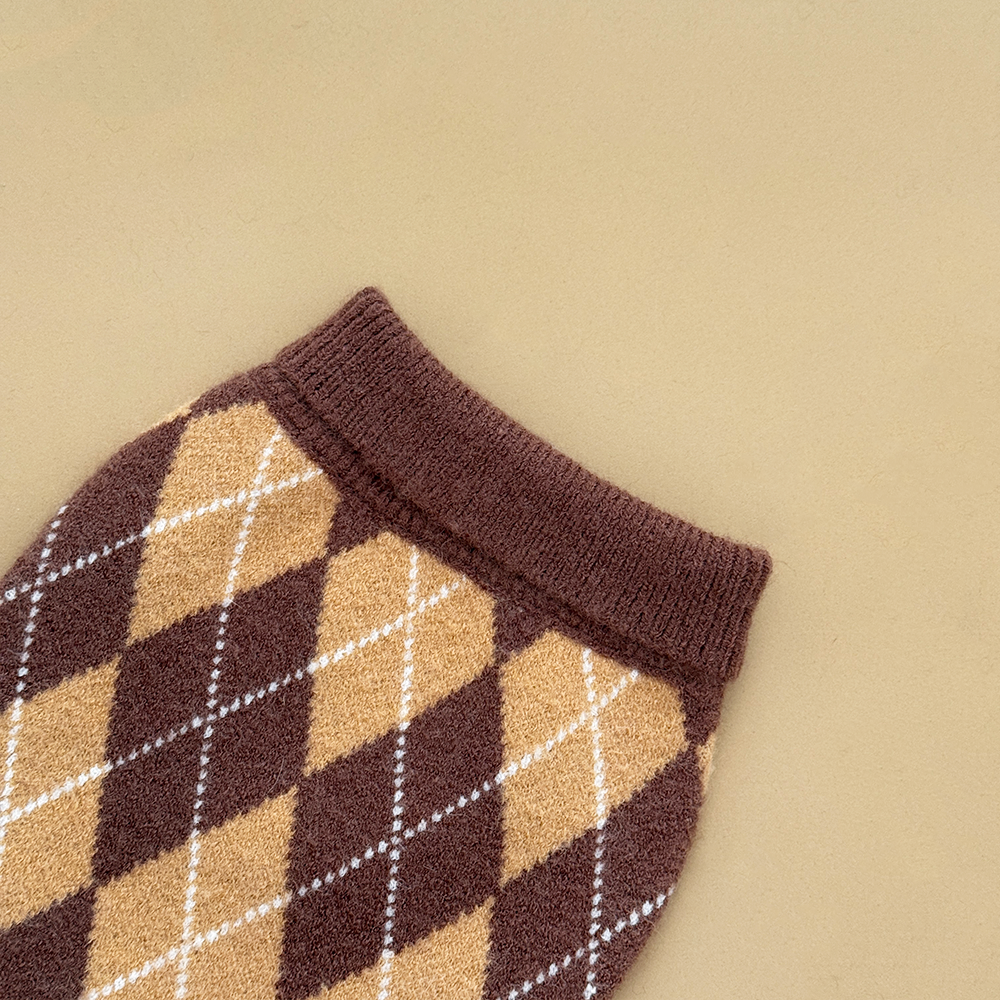 Close up of the neck of a dog jumper in a brown, tan, and white argyle pattern. 