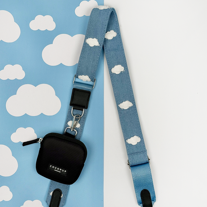 Blue Bag Strap featuring white cloud patterns on a blue background with white clouds. Attached is a Cocopup Black Treat Pouch.