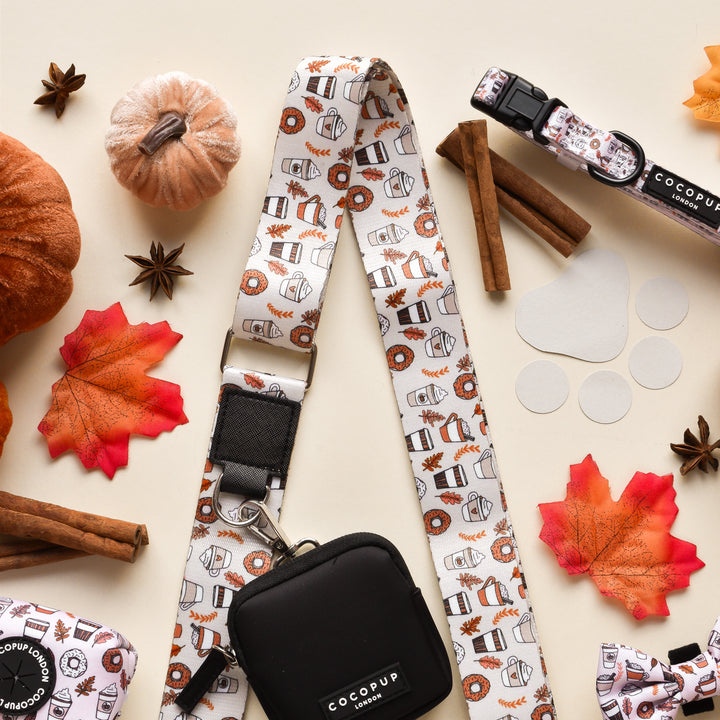 A group of objects on a white surface, featuring the "Bag Strap - Autumn Puppuccino" by Cocopup London.